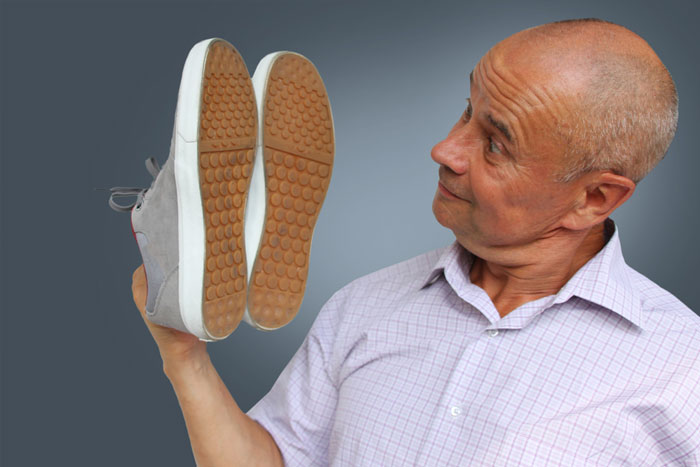 man looking at buying shoes to help with his lower back pain