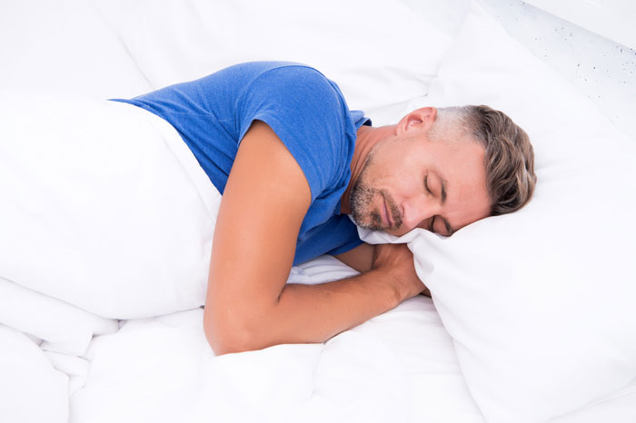man sleeping on his left side with lower back pain