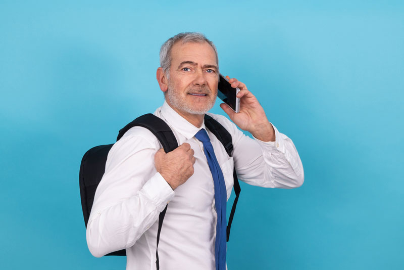 middle aged man on phone whilst wearing business backpack