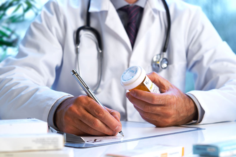 doctor writing prescription for opioids