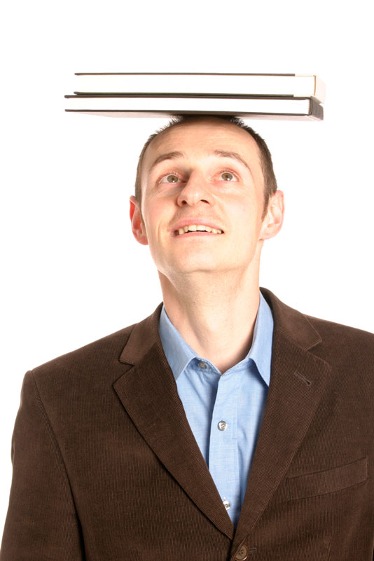 middle aged man showing good posture whilst balancing books on his head
