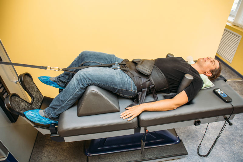 man lying on spinal decompression machine table
