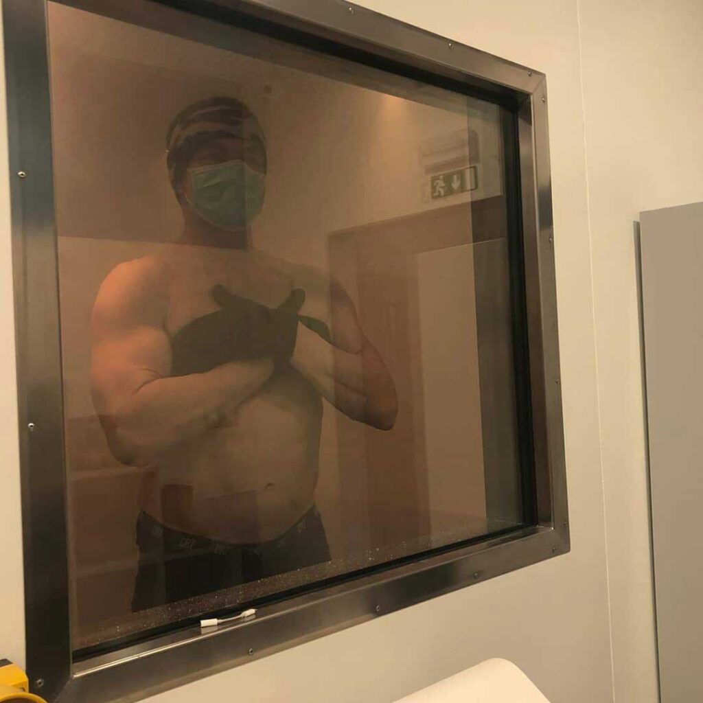 man inside cryotherapy chamber looking outside