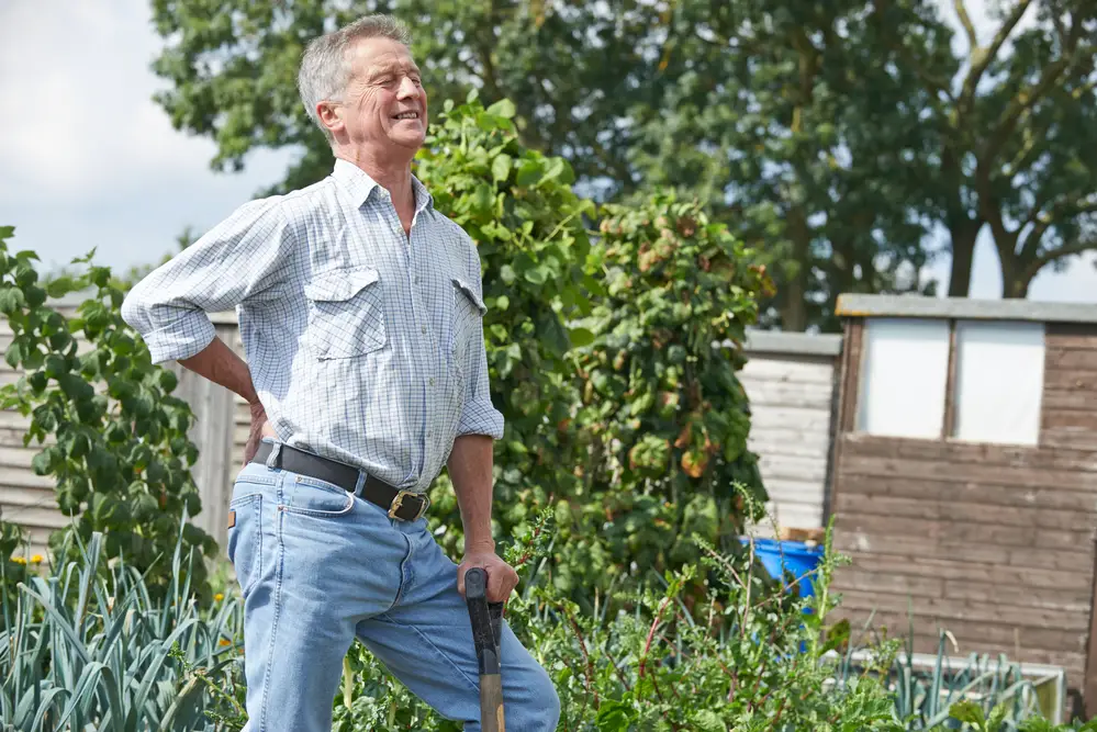 middle aged man gardening with lower back pain