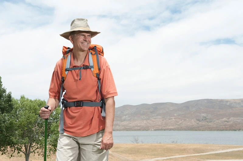 middle aged man with low back pain walking outdoors